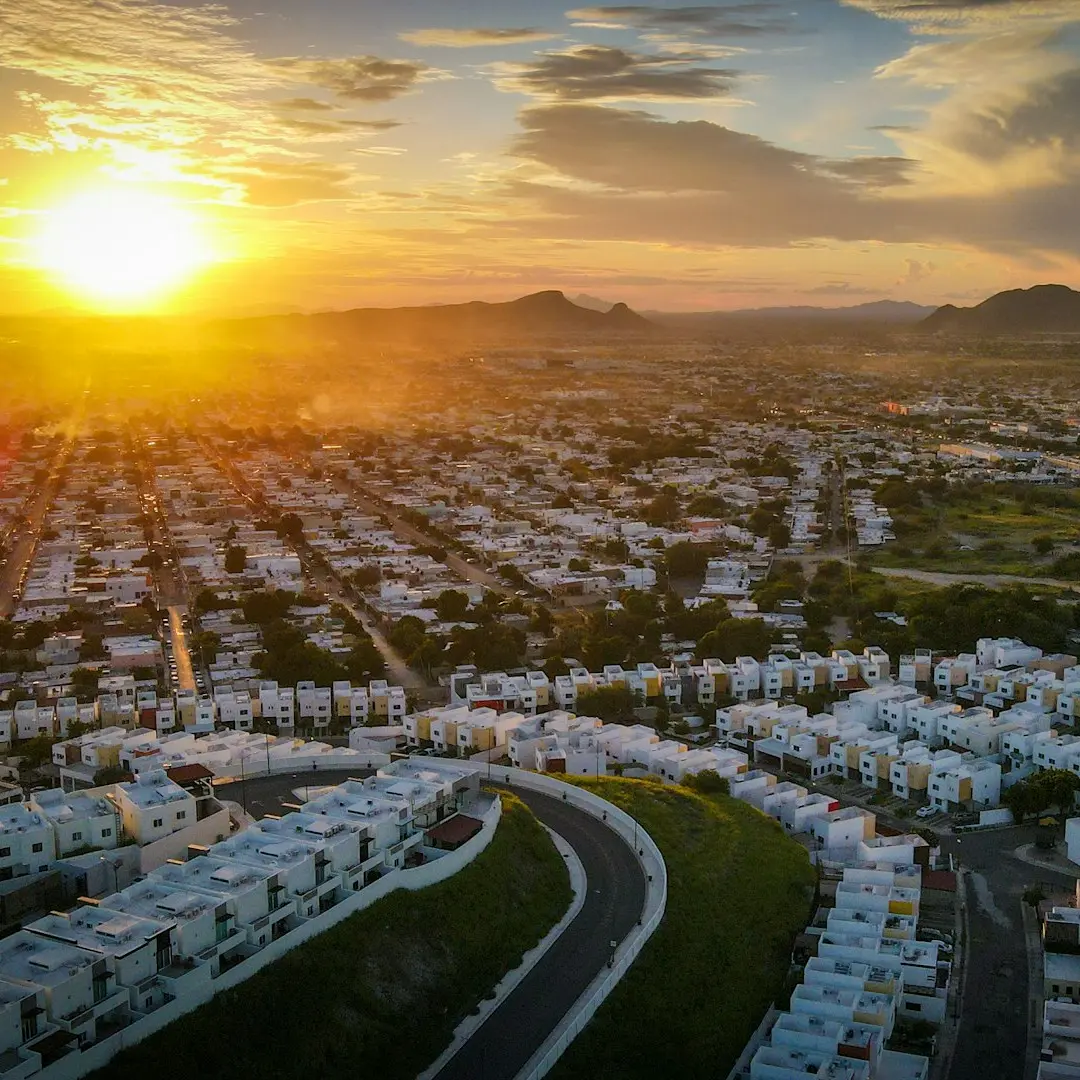 a city with a road and a sunset